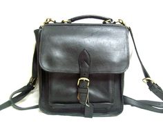 "This here truly is a beautiful vintage handmade black leather backpack! It is made from a very durable, thick black leather, inside and out. The bag has nice brass accents (the buckle, the D-rings, and the latches). The bag has a leather \"dog tag\" that reads \"COACH\" (not a Coach bag, seems to have been added). There is also a front pocket. This bag definitely does show some signs of wear such as scuffs and scratches on the leather, and some scratches and tarnishing on the brass hardware - b Unisex Backpack, Black Leather Backpack, D Rings, Brass Accents, Coach Bag, Dog Tag, Backpack Purse, Black Backpack, High Quality Leather