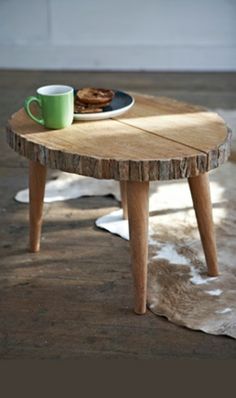 a wooden table with a plate of cookies on it next to a cup of coffee