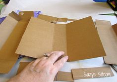 someone cutting out pieces of cardboard with scissors