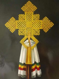 the cross is made out of gold and white material with red, green, yellow, and blue stripes