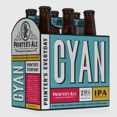 six bottles of cyan beer sitting in a cardboard box on a white background with the words printer's ale printed on it