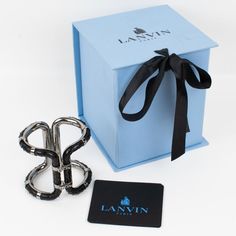 A sophisticated Lanvin Paris modernist clamper bracelet.  This statement piece features an oversized gray steel framing in a futuristic design ornate with black python leather skin. The bracelet is engraved inside: "Lanvin Paris - Made in Italy." The two locking clasps are working perfectly. We will deliver the bracelet with its original branded gift box and label. Measurements: inside across is 2.25 in wide x 1.75 in deep (5.7 x 4.5 cm) - width is 2.75 in (7 cm) - inner circumference is 6.69 in Luxury Rectangular Cuff Bracelet For Formal Occasions, Luxury Metal Evening Cuff Bracelet, Luxury Black Metal Cuff Bracelet, Modern Evening Cuff Bracelet, Luxury Black Cuff Bracelet, Designer Black Cuff Bracelet For Gift, Designer Black Cuff Bracelet As Gift, Designer Black Cuff Bracelet For Formal Occasions, Designer Cuff Bracelet For Evening