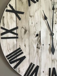 a clock made out of wood with roman numerals on the face and hands