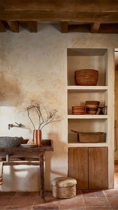 a rustic style kitchen with open shelving and bowls on the shelves, including a sink