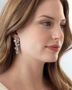 a close up of a person wearing some kind of earring with flowers on it