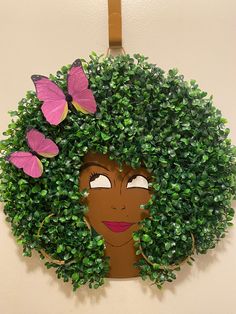 a woman's face is surrounded by green leaves and pink butterflies on a white wall