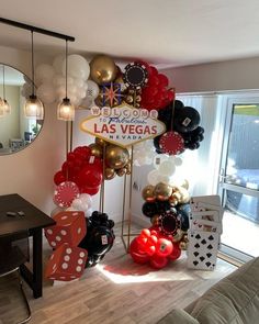 a room filled with balloons and decorations in front of a large sign that says welcome to las vegas