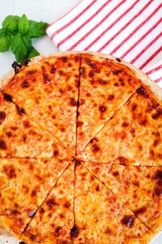 a cheese pizza cut into eight slices on a white plate with a red and white napkin