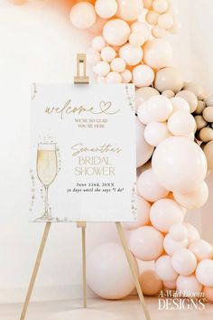 a welcome sign with champagne glasses and balloons in the background for an elegant bridal shower