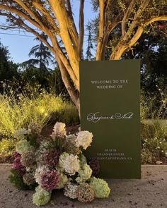 a welcome sign with flowers in the foreground