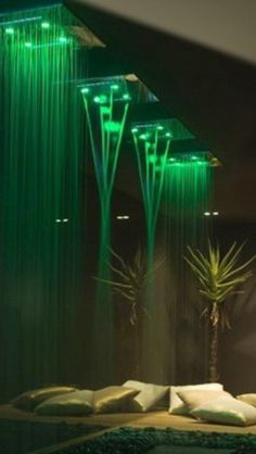 a large shower head with green lights on it's sides and water running down the side