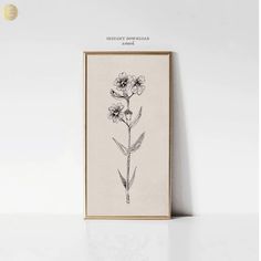 a black and white drawing of flowers on a wall next to a framed photograph with the words