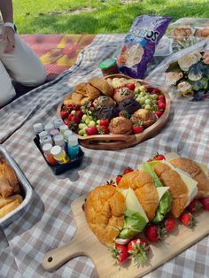 a picnic table with sandwiches and fruit on it