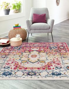 a living room with an area rug, chair and potted plant