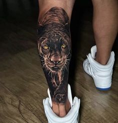 a man's leg with a black and grey tiger tattoo on his left calf