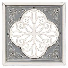 an ornate design on the side of a white and gray tile wall mounted heat grate