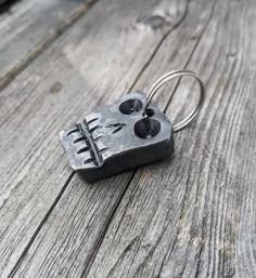 a pair of scissors is attached to a key chain on an old wooden plank surface