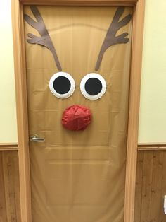 a door decorated to look like a reindeer's head with googly eyes and nose