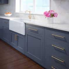 a kitchen with blue cabinets and white counter tops