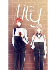 two people standing next to each other in front of a brick wall with the words yuu written on it