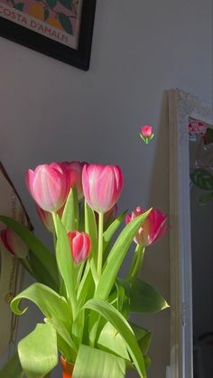 pink tulips are in a vase on the table