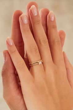 a woman's hand with two rings on it