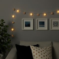 a living room filled with furniture and pictures hanging on the wall next to a potted plant