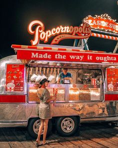 a woman standing in front of a food truck