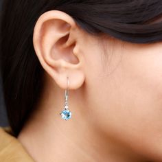 Product Details These elegant drop earrings feature stunning round shape swiss blue topaz stone, and shimmering Moissanite set in prong setting. The earrings are crafted in luxurious gold and hang from delicate fish hook backs, adding a touch of sophistication to any outfit. The beautiful blue topaz stone are offset by the glittering Moissanite, creating a mesmerizing and eye-catching look. These classic earrings are the perfect accessory for adding a pop of color and sparkle to any outfit, maki Solitaire Earrings, Blue Topaz Stone, Classic Earrings, Sky Blue Topaz, Signature Jewelry, Swiss Blue Topaz, Topaz Stone, Diamond Drops, Diamond Drop Earrings