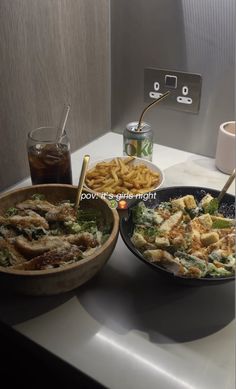 two plates of food sitting on a counter next to a cup and saucer with a spoon in it