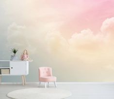 a pink chair sitting in front of a wall with clouds painted on the wall behind it