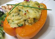 an orange stuffed with food sitting on top of a white plate