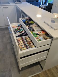 an open drawer in the middle of a kitchen