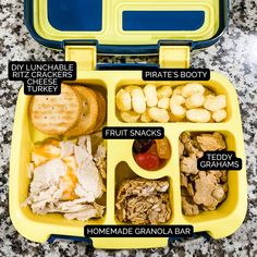 a yellow lunch box with compartments filled with food and words describing the different foods in it