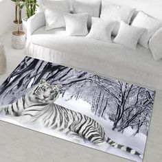 a white tiger laying on the ground in front of a couch with pillows and throw pillows