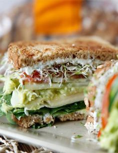 a sandwich cut in half sitting on top of a white plate with cheese and lettuce