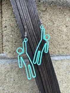 the earrings are made out of wire and have two people hanging from each earring