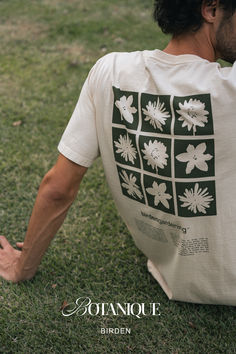 a man sitting on the grass with his back to the camera