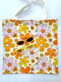 Add a splash of vintage charm to your daily routine with our Retro Floral Tote Bag! This eye-catching bag features a delightful pattern of large, colorful flowers in vibrant hues of orange, pink, and yellow on a cream background. Perfect for adding a fun, nostalgic touch to any outfit, this tote is as practical as it is stylish. Key Features: *Material: Made from durable, eco-friendly cotton canvas. *Design: Retro-inspired floral print that brings a cheerful, 70s vibe. *Size: Spacious enough to carry all your essentials - groceries, books, or beach gear. *Handles: Sturdy and comfortable over-the-shoulder straps for easy carrying. *Versatility: Ideal for shopping, picnics, beach trips, or everyday use. Why You'll Love It: *Sustainable: Reduce your plastic footprint with this reusable bag. * Green Retro Aesthetic, Green Retro, Beach Gear, Beach Trips, Cream Background, Bag Cute, Bag Canvas, Retro Aesthetic, Reusable Bags