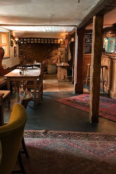 the interior of a restaurant with wooden tables and chairs in front of an open fire place