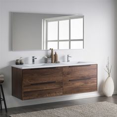 a bathroom vanity with two sinks and a large mirror over the sink, in front of a window