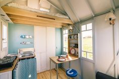 a kitchen with a stove top oven sitting next to a wooden table in a room