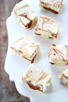 several pieces of cheesecake on a white plate with chocolate drizzled over them