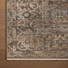 an area rug that is on top of a wooden floor with a brown and tan color scheme