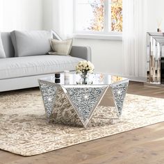 a living room with a couch, coffee table and fire place in the middle of it