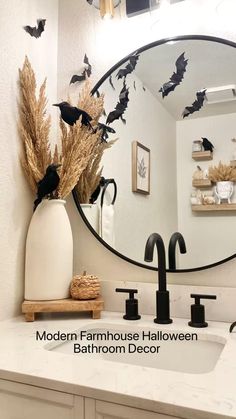 a bathroom sink with a mirror above it that has black birds flying over the counter