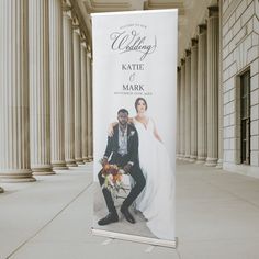 a couple posing in front of a wedding sign