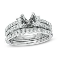 a white gold wedding ring set with two rows of diamonds on each band and the center diamond