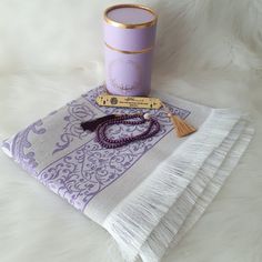 a purple candle and tassel on a white furnishing with a gold trim