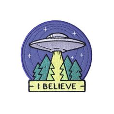 an embroidered patch with the words i believe in front of trees and an alien spaceship